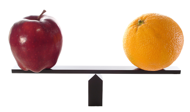 An apple and an orange balanced on a scale