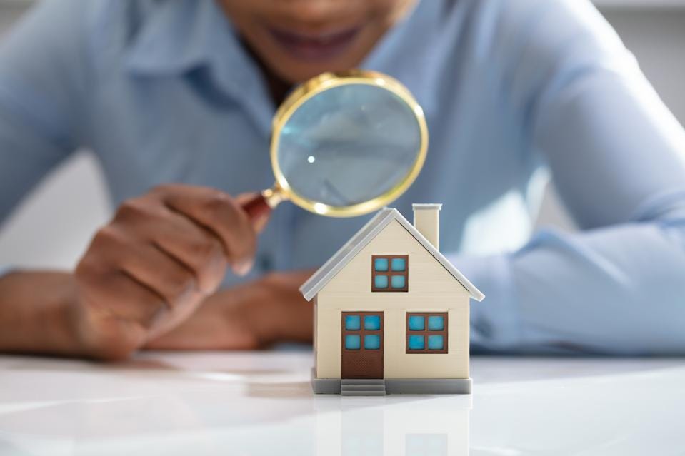 A model home examined through a magnifying glass